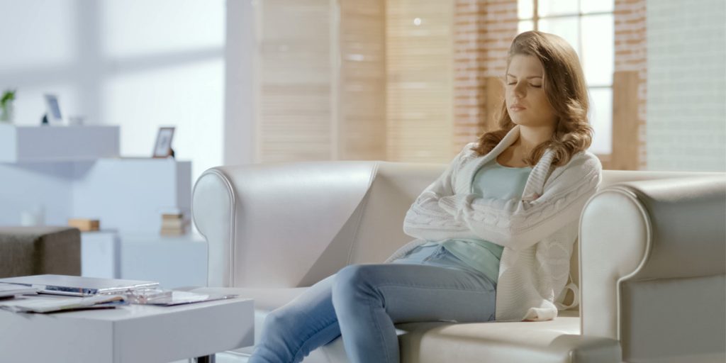 Staying-centered-in-difficult-times A young woman sitting with her eyes closed in the midst of difficult times.